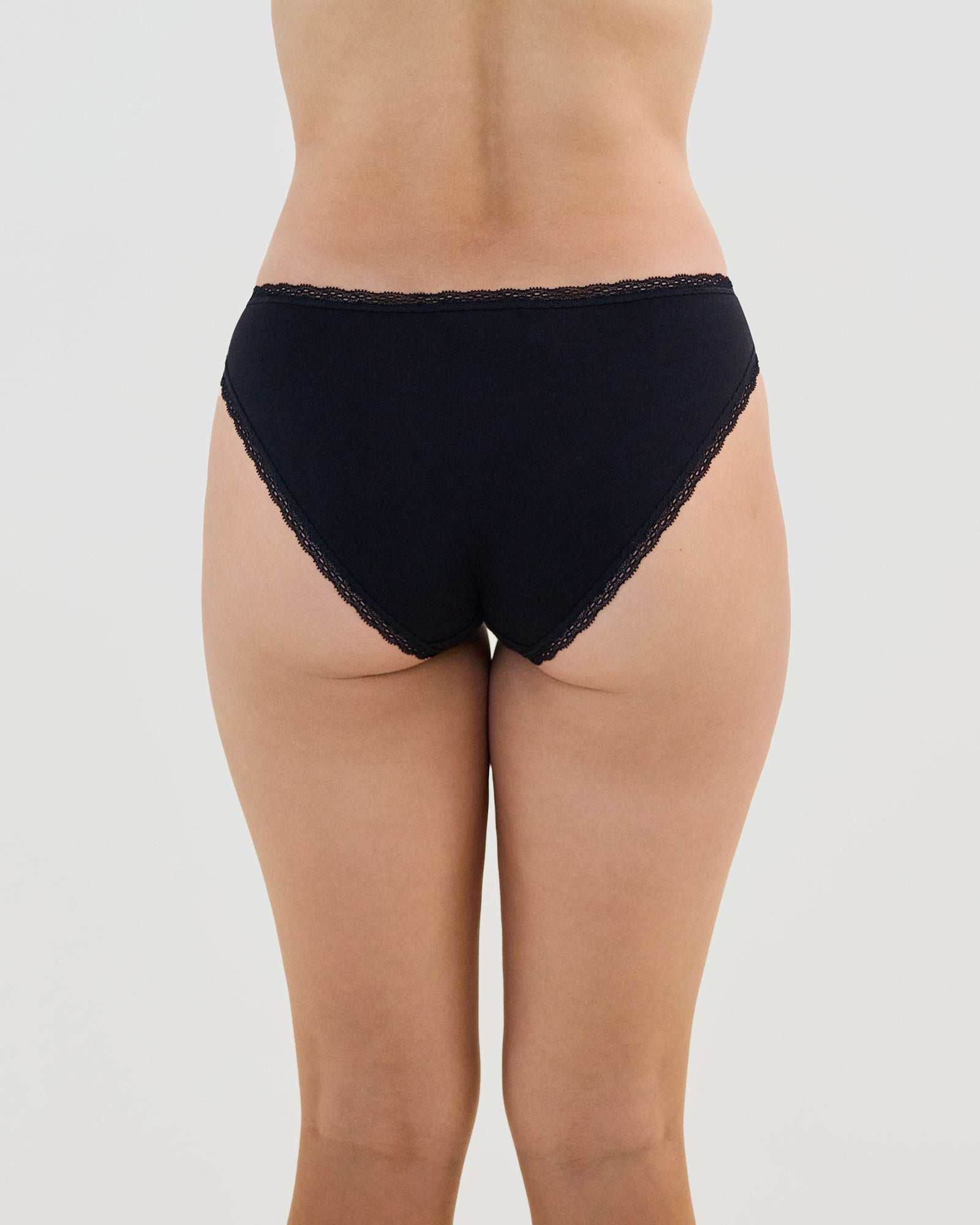 Model wears Stretch Cotton Bikini in BLACK. On body back view