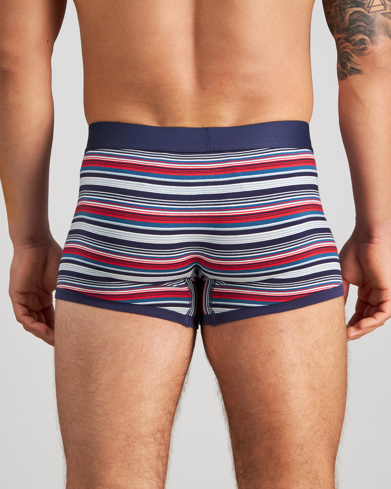 Model wears Bold Stripe Mens Trunk in PEACOAT/SALSA STRIPE. On body back view