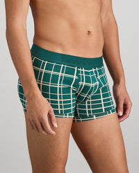 Model wears Retros Print Mens Trunk in RAIN FOREST GRID PRINT. On body side view