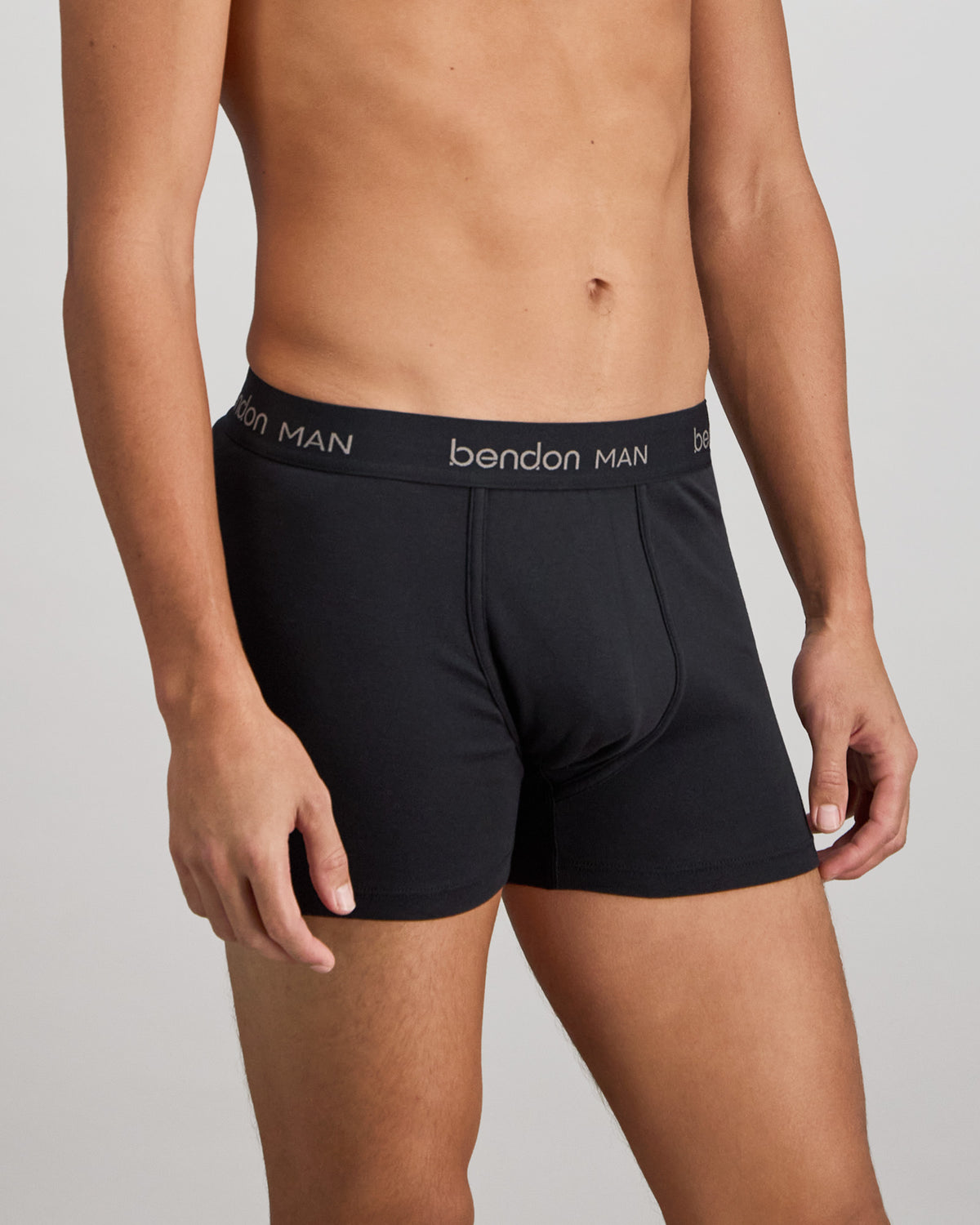 Model wears Cotton Classics Mens Trunk in BLACK. On body side view