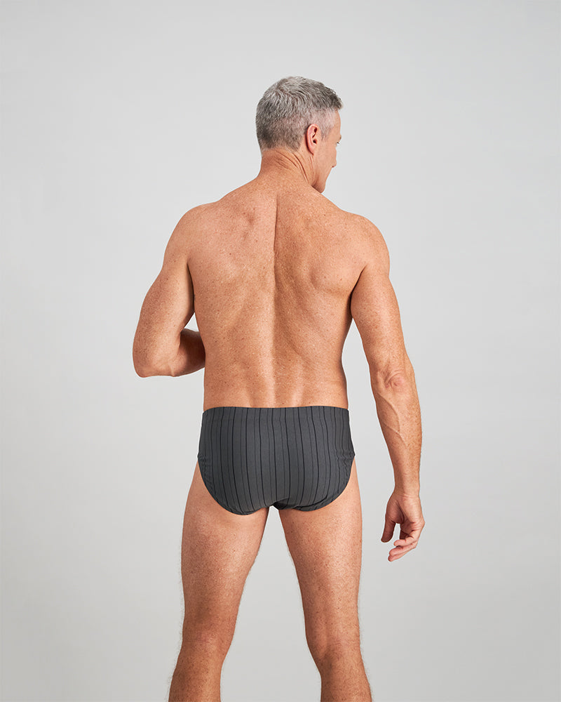 Model wears Cotton Stretch Mens Brief in CHAR BLACK. On body back view