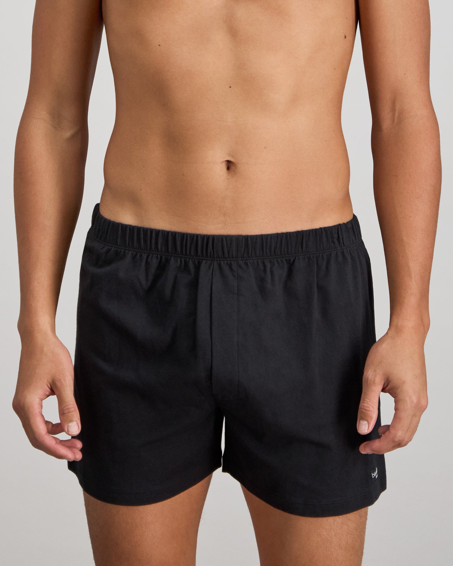 Model wears Cotton Basics Mens Trunk in BLACK. On body front view