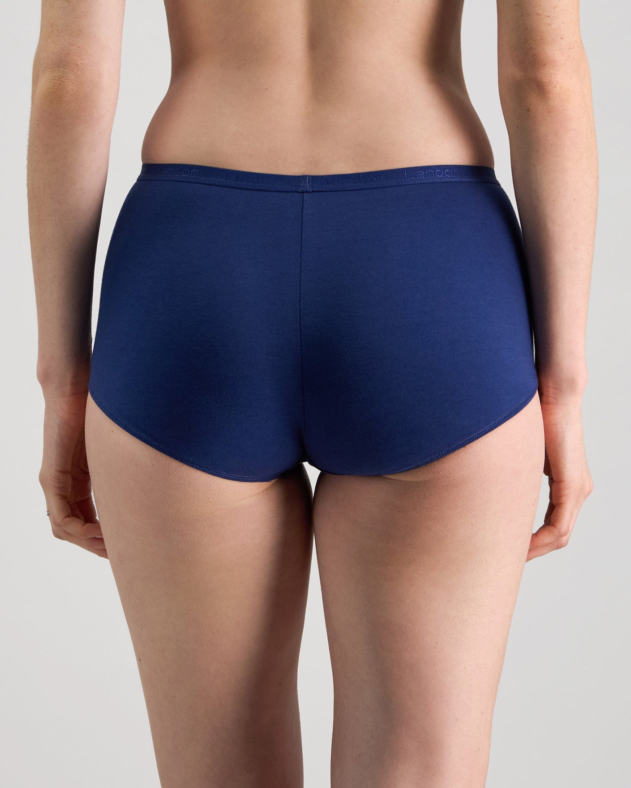 Model wears Body Cotton Full Brief in Medieval Blue. On body back view