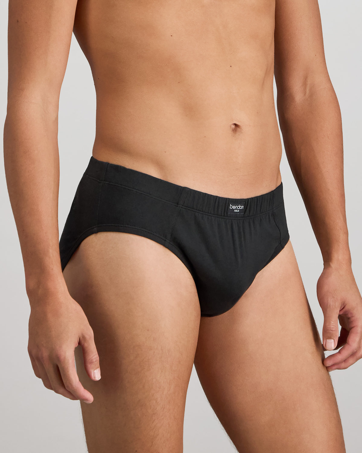 Model wears Cotton Stretch Mens Brief in BLACK. On body side view