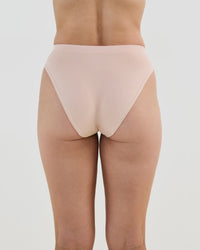 Model wears Seamless Soft High Cut Brief in LATTE. On body back view