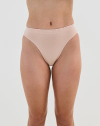 Model wears Seamless Soft High Cut Brief in LATTE. On body front view