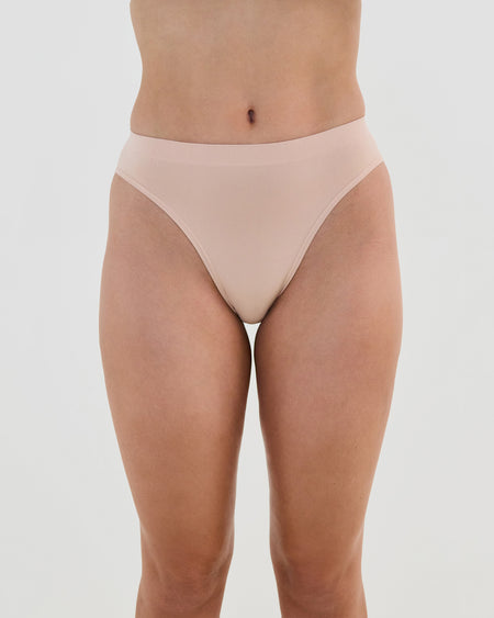 Model wears Seamless Soft High Cut Brief in LATTE. On body front view