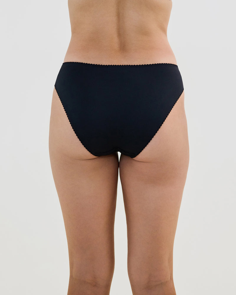 Model wears Lacey Bikini in BLACK. On body back view