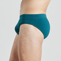 Model wears High Tech Cotton Mens Brief in DEEP TEAL. On body side view