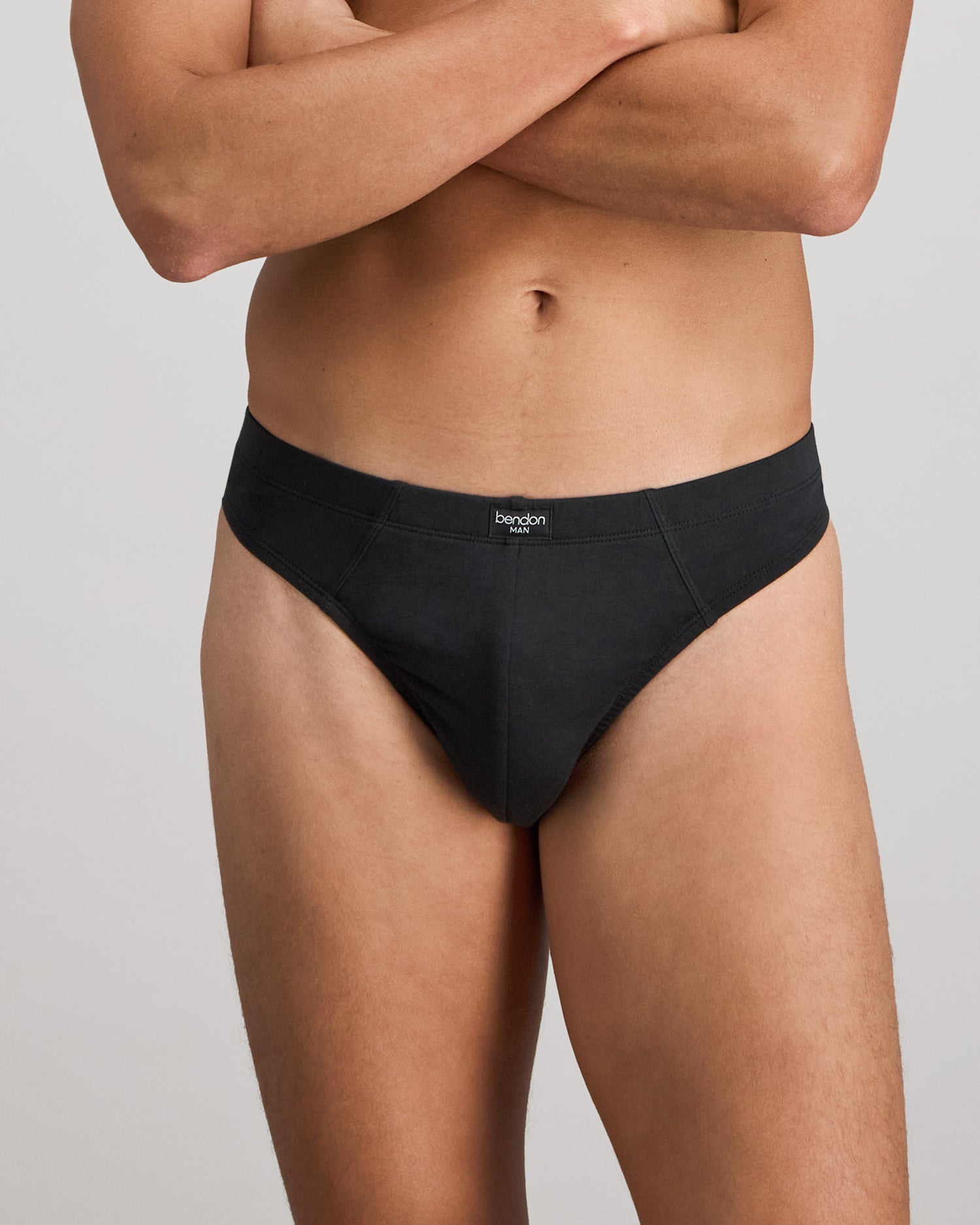 Model wears Cotton Stretch Mens Thong in BLACK. On body front view