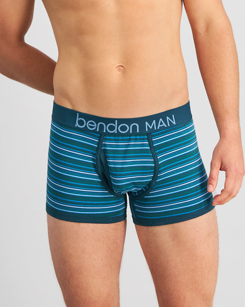 Model wears Bold Stripe Mens Trunk in DEEP TEAL/DEEP LAKE. On body front view