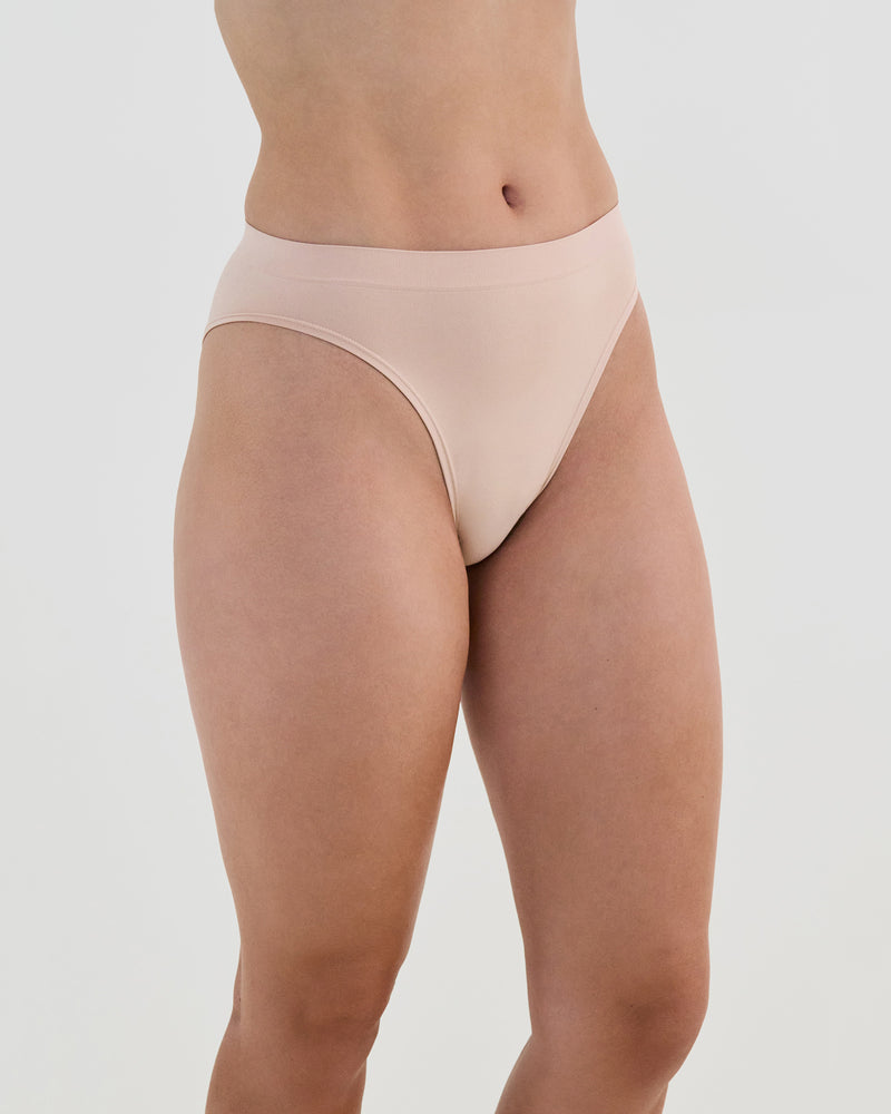 Model wears Seamless Soft High Cut Brief in LATTE. On body side view