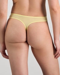 Model wears Sunlit Thong in LEMON MERINGUE. On body back view