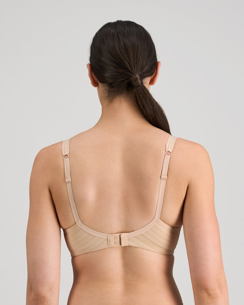Model wears Rita Contour Bra in LATTE. On body back view