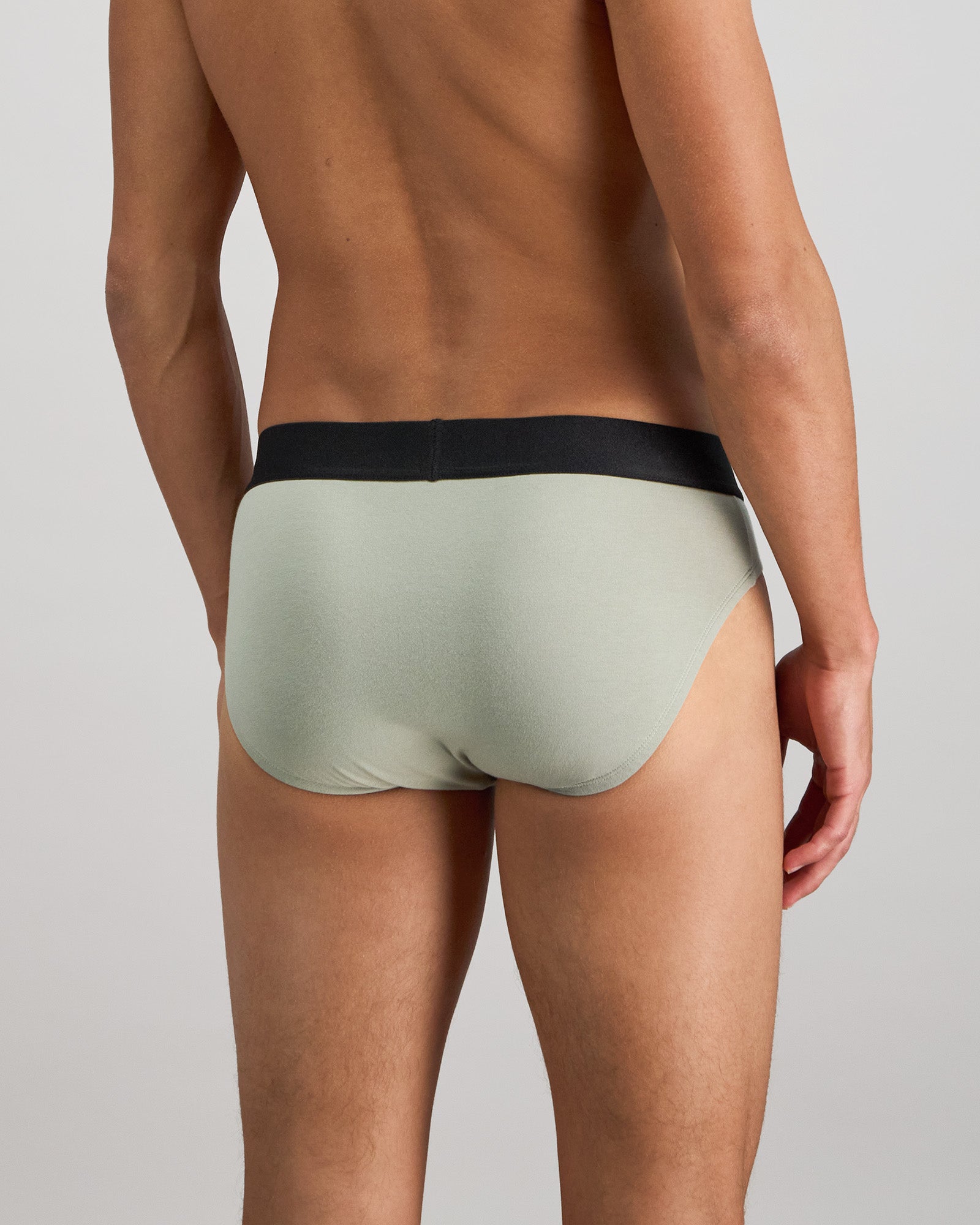 Model wears Everyday Essential Mens Brief in ICEBERG GREEN. On body back view