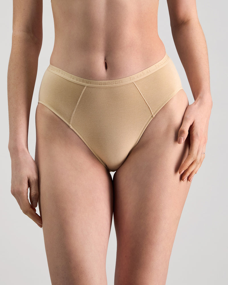 Model wears Body Cotton High Cut Brief in NATURAL. On body front view