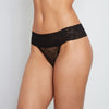 Model wears Lace Thong in BLACK. On body front view