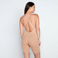 Model wears Medium Control Jumpsuit in CARAMEL. On body back view