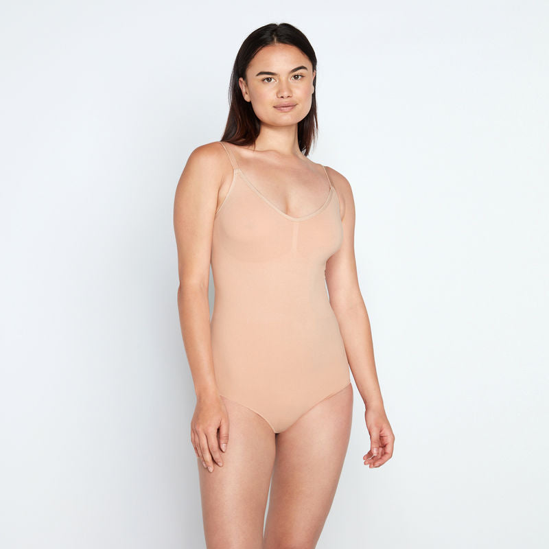 Model wears Medium Control Bodysuit in CARAMEL. On body front view