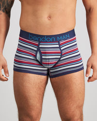 Model wears Bold Stripe Mens Trunk in PEACOAT/SALSA STRIPE. On body front view