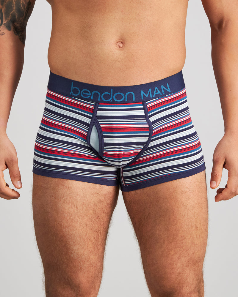 Model wears Bold Stripe Mens Trunk in PEACOAT/SALSA STRIPE. On body front view