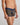 Model wears Bold Stripe Mens Trunk in BLACK/OAK BUFF STRIPE. On body side view