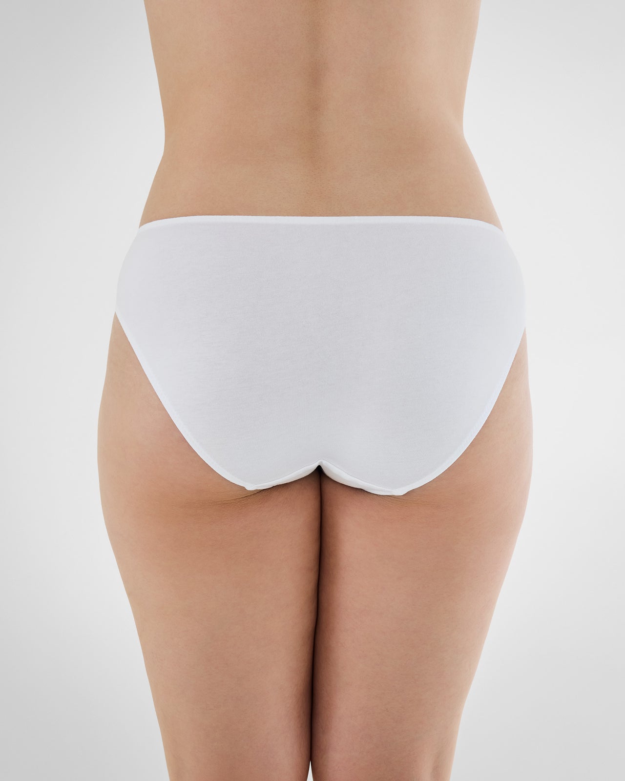 Model wears Embrace Bikini in WHITE. On body back view