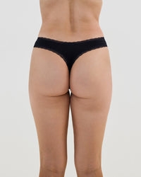 Model wears Stretch Cotton Thong in BLACK. On body back view