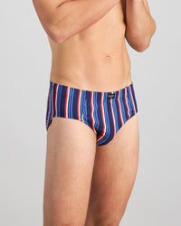 Model wears Cotton Stretch Mens Brief in BITTERSWEET/REGATTA STRIPE. On body side view