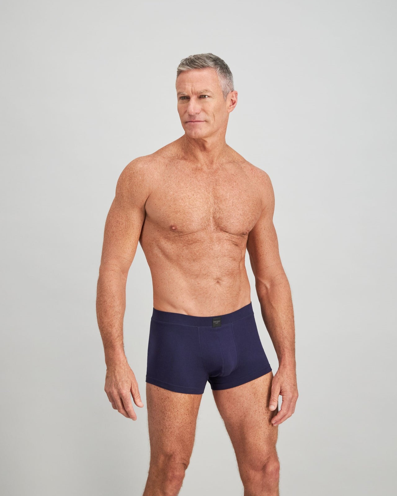 Model wears High Tech Cotton Mens Trunk in PEACOAT. On body side view