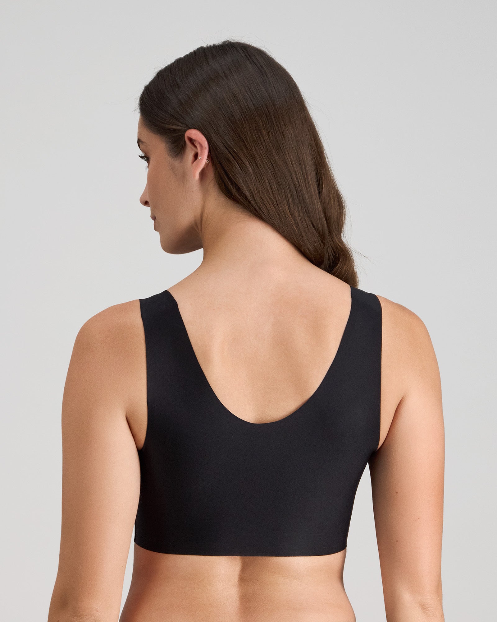 Model wears Comfit Collection Crop Top in BLACK. On body back view