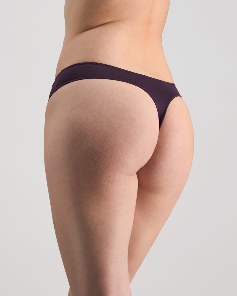 Model wears Au Naturel Thong in PLUM PERFECT. On body side view