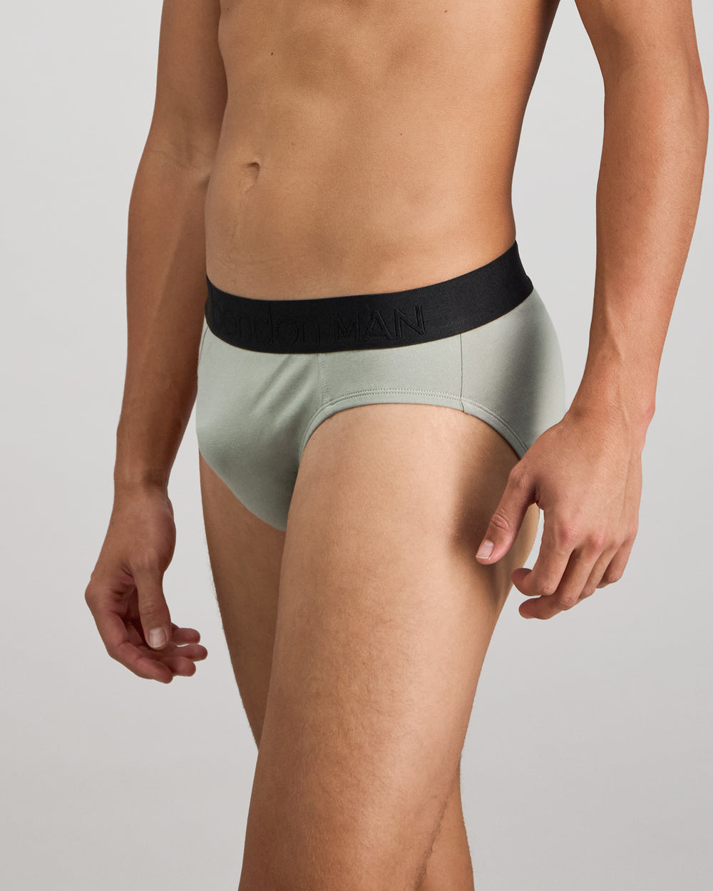 Model wears Everyday Essential Mens Brief in ICEBERG GREEN. On body side view