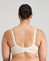 Model wears Delicate Lace Underwire Bra in IVORY/CREAM TAN. On body back view