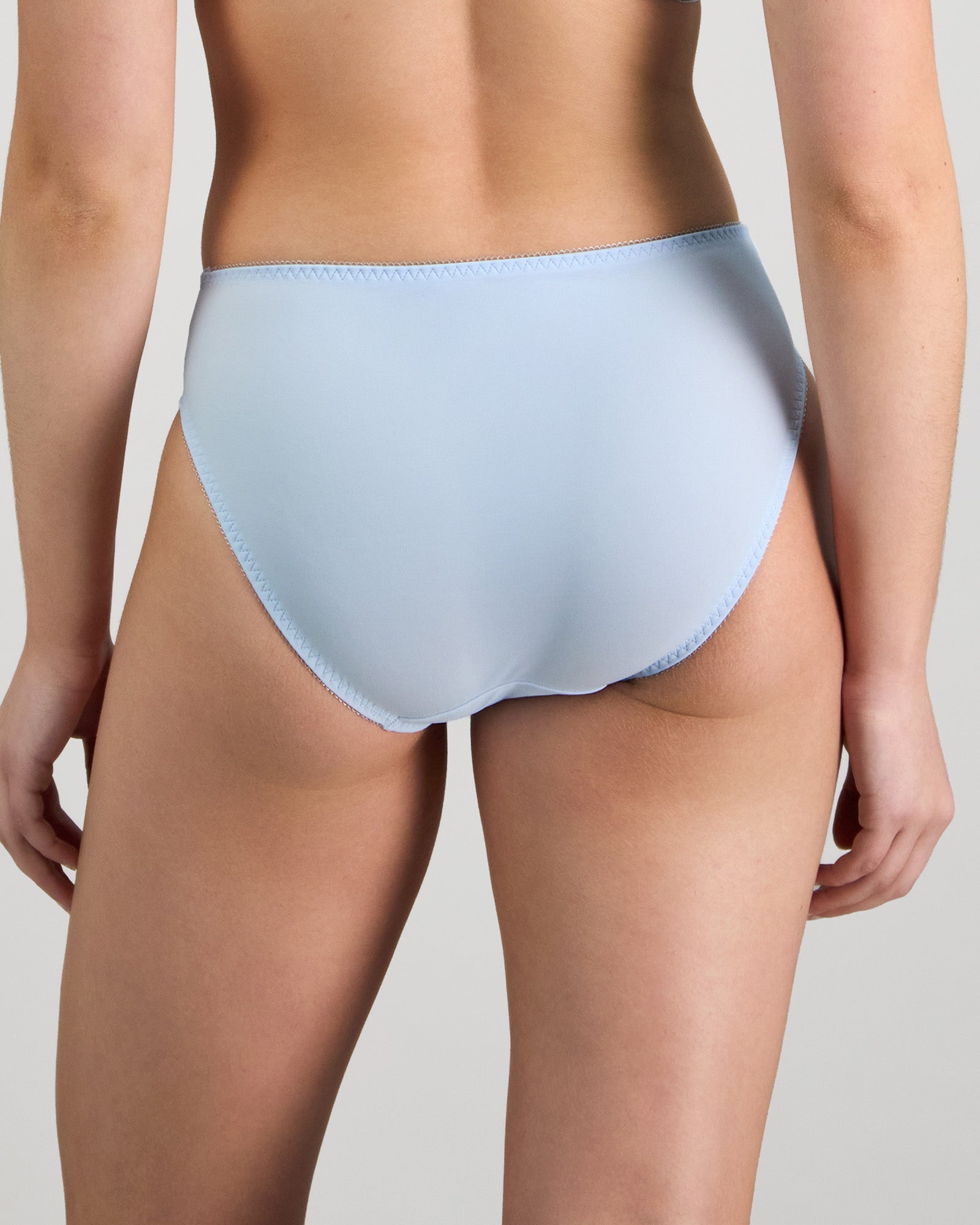 Model wears Coral High Cut Brief in SKYWAY. On body back view