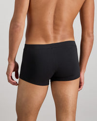 Model wears High Tech Cotton Mens Trunk in BLACK. On body back view