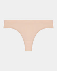 Model wears Seamless Thong in LATTE. On body front view