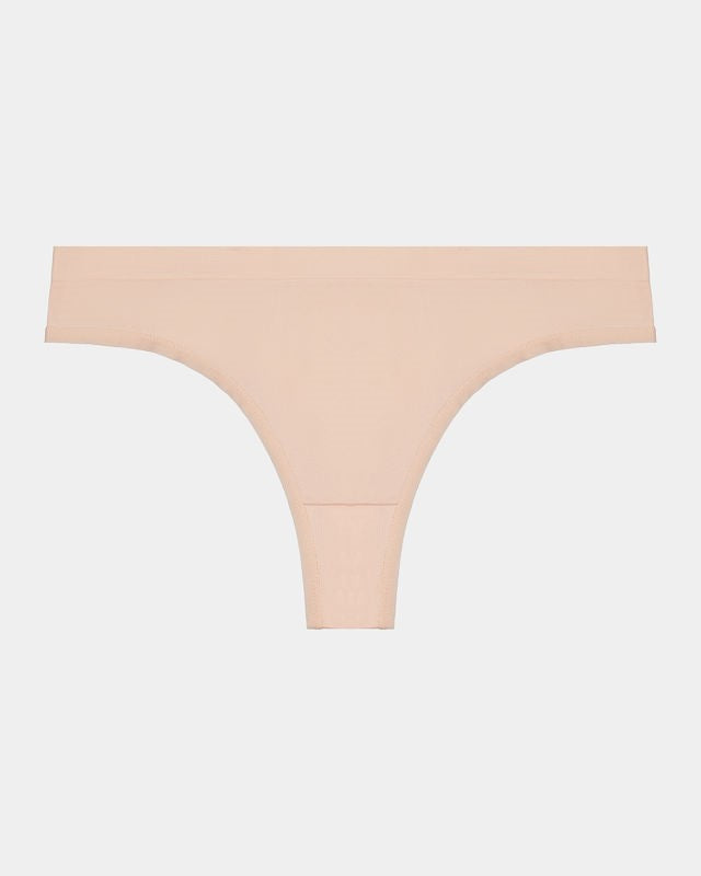 Model wears Seamless Thong in LATTE. On body front view