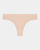 Model wears Seamless Thong in LATTE. On body front view