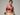 Woman wearing a pink bra and beige pants against a gray background