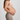Pregnant woman wearing a beige maternity bra and leggings against a light gray background