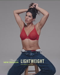 model-ties-hair-up-wearing-a-red-mesh-bra